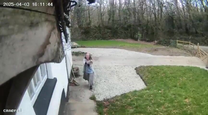 Camera still from A second view: holding her arm at the doorway